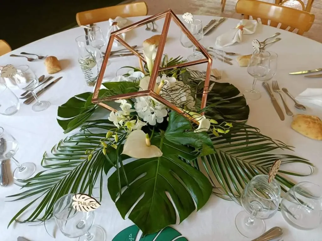 floral centerpiece, with gold square-shaped columns and floral arrangement.